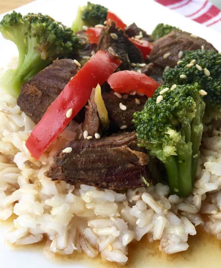 Beef and Broccoli over rice with a red pepper slice on top