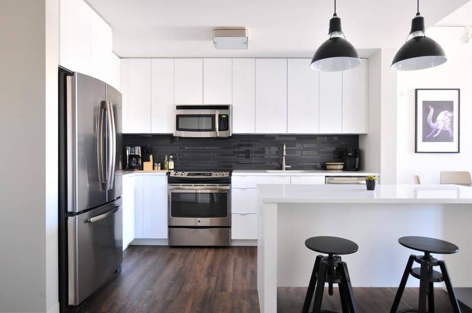 White kitchen with a silver microwave and silver fridge