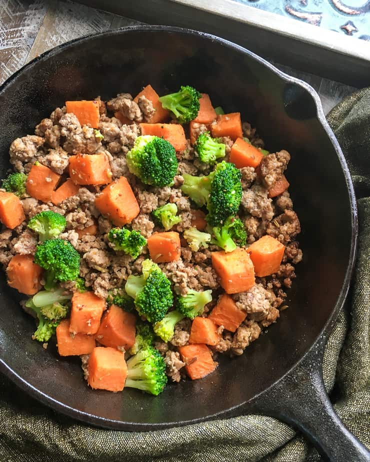 turkey sausage with sweet potatoes and broccoli in a cast iron skillet 