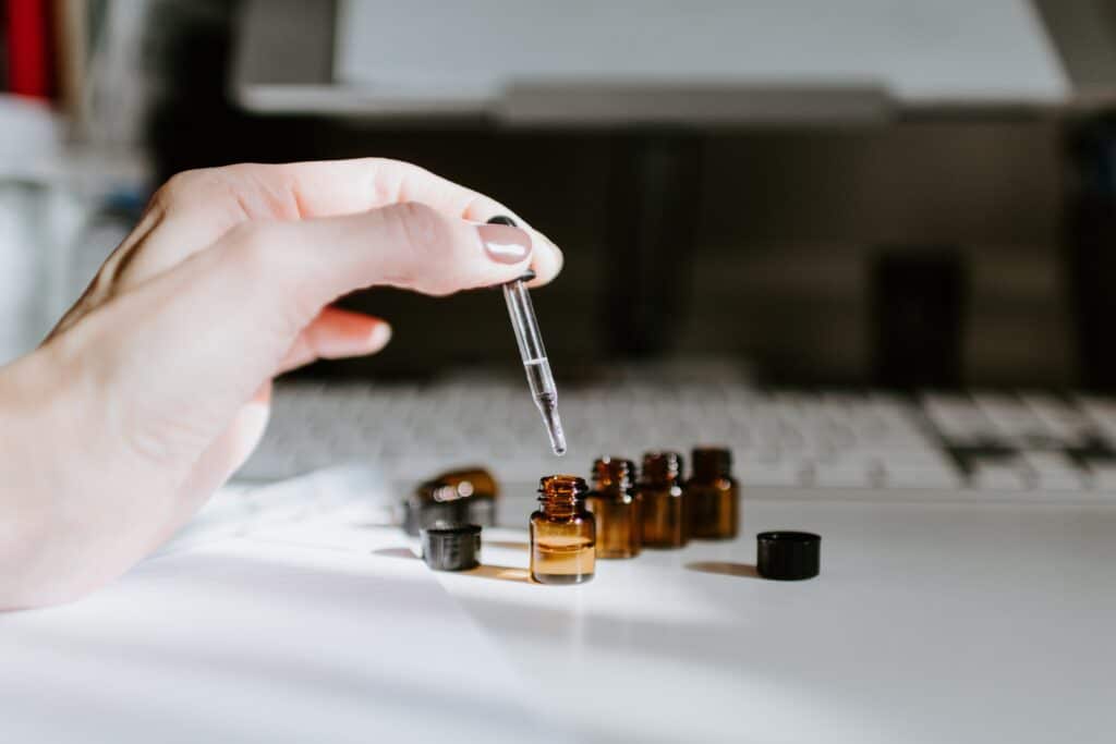 Essential oils. A hand dropping oil into little jars