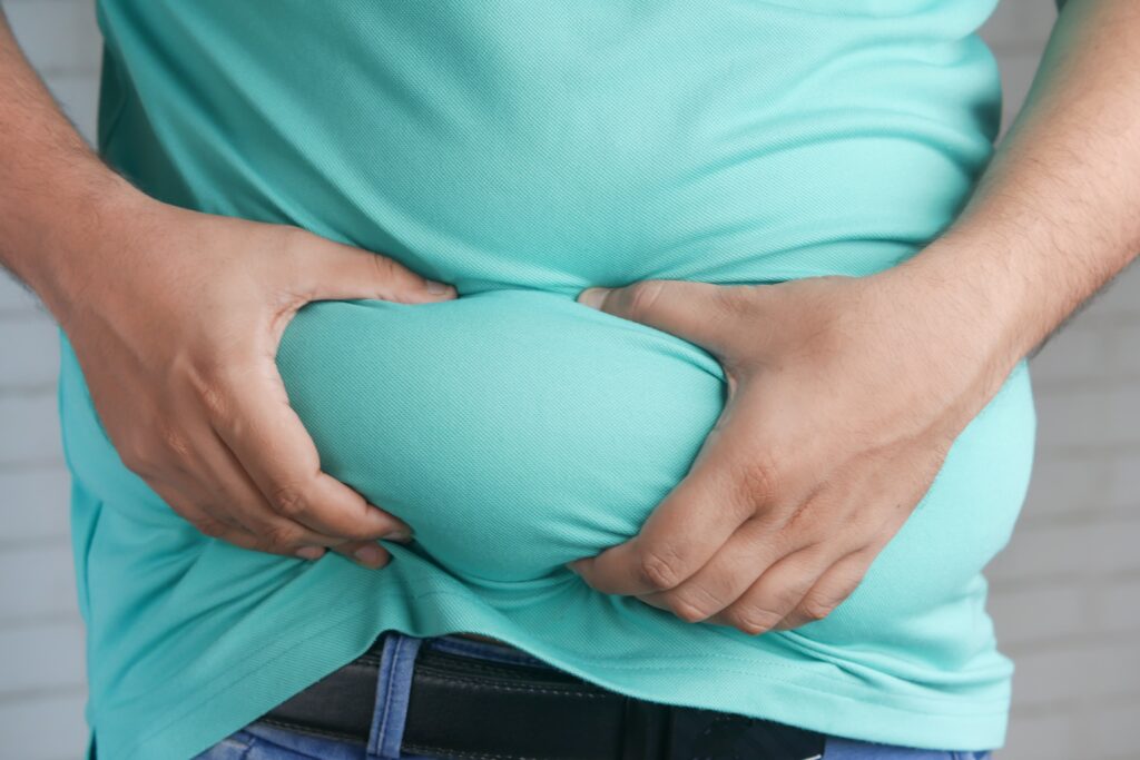 Man in a green shirt grabbing his fat