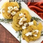 Golden Beets arranged on a white platter garnished with thyme and pistachios