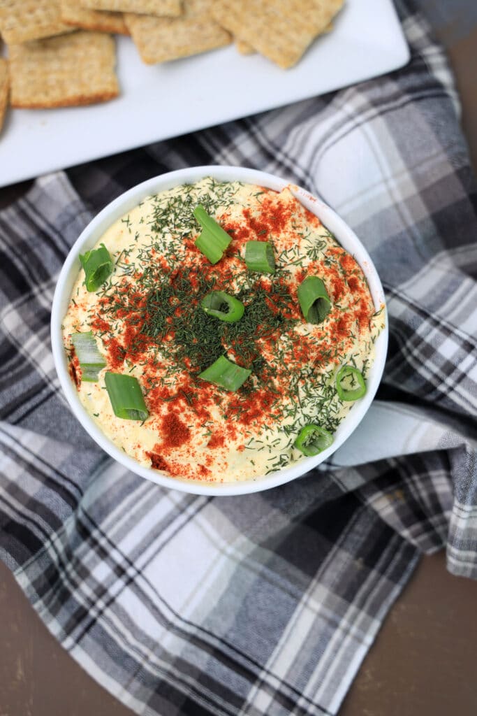 deviled egg dip in a bowl on a plaid cloth