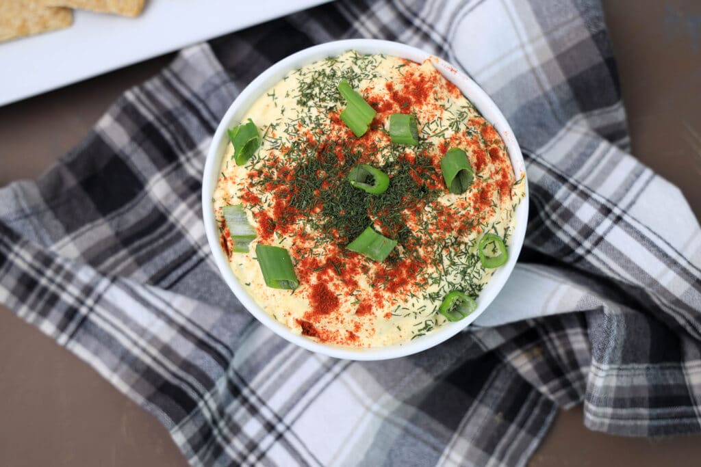 Low Point Deviled Egg Dip in a white bowl on a black and white napkin