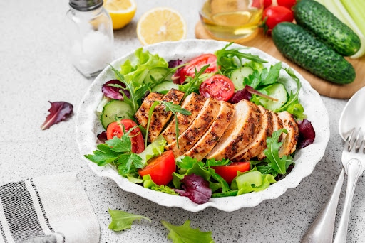 Grilled chicken breast, fillet and fresh vegetable salad. Healthy lunch menu.