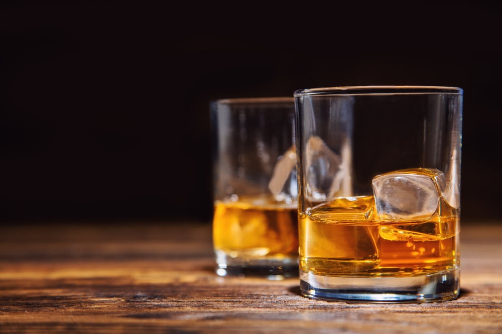 Two glasses of whiskey with ice cubes