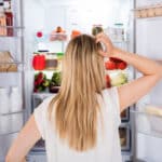 Young lady opened the fridge and, in frustration.