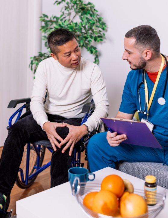 Patient in a wheelchair is talking with a doctor in a room